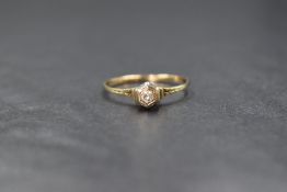 A yellow metal presumed gold diamond set solitaire, the illusion set round cut diamond in a