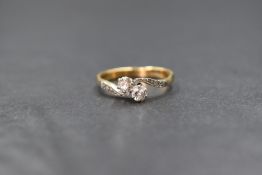 An 18ct gold two stone diamond ring, having two 0.128ct stones in a crossover setting to diamond