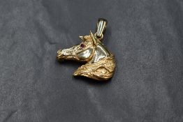 A 9ct gold pendant modelled as a horse's head with ruby set eye, approx 13g & 35mm x 40mm inc loop