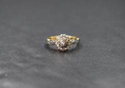 An 18ct gold diamond set cluster ring, the central bezel illusion set diamond in an eight illusion