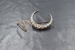 A Victorian diamond set crescent brooch, in the form of a crescent moon set with twenty five