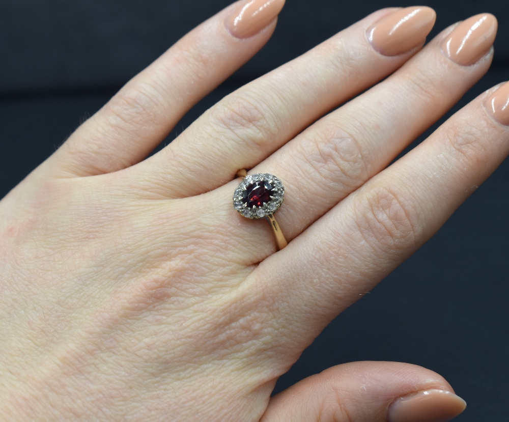A 9ct gold garnet and white gemstone set cluster ring, the central oval cut garnet in a ten white - Image 3 of 3