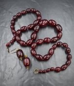 A long knotted string of graduated cherry amber style beads, approx 36' long and approx 130.6g,