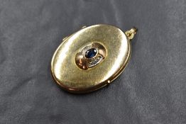 A 9ct gold sapphire and diamond set locket, the central bezel set oval sapphire with illusion set