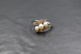 An Edwardian 18ct white gold pearl and diamond set ring, the three central graduated pearls having a
