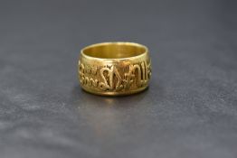 A yellow metal presumed gold zodiac band, having raised zodiac symbols to the exterior, tests as