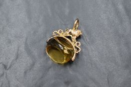 A large triple faced cut citrine swivel fob having a yellow metal mount with moulded lion