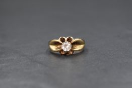 A 9ct gold gemstone set gypsy ring, the round cut clear gemstone possibly topaz or spinel in a six