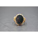 A yellow metal presumed gold bloodstone set signet ring, the oval bezel set bloodstone panel in a