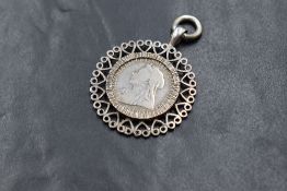A Victorian one shilling coin, in a white metal decorative mount, 11.4g