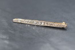 A Victorian yellow metal graduated diamond bar brooch having twenty one old cut and rose cut