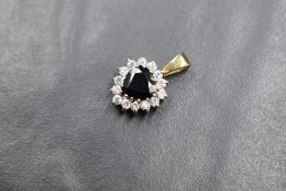 A yellow metal presumed gold sapphire and cubic zirconia set heart pendant, the central heart cut