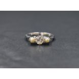 An 18ct white gold pearl and diamond set trilogy ring, the central old cut diamond measuring