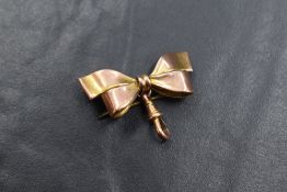 A 9ct gold bow brooch, the ribbon bow having a dog clip and brooch back, marked 375, 3.7g
