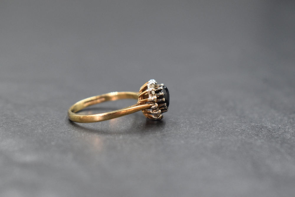 A 9ct gold sapphire and diamond set cluster ring, the central heart cut sapphire in a fourteen - Image 2 of 2