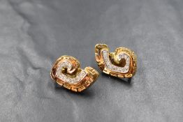 A pair of 18ct gold diamond set earrings, the spiral motif earrings with meander border, each set