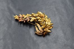 An 18ct gold diamond set spray brooch, the leaf motif spray set with round cut diamonds to the