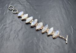 A silver moonstone set bracelet, the eight lozenge bezel set moonstone cabochons, in an