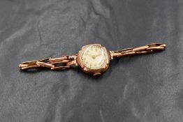 A 9ct rose gold wristwatch, the champagne dial having Arabic numerals, on a 9ct gold bracelet strap,