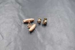 A single 9ct rose gold cufflink, of oval form having decorative engraving and chain link, marked