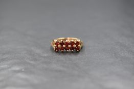 A 9ct gold garnet set ring, the two rows of five round cut garnets in claw settings with split