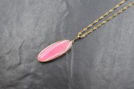 A 9ct gold pink agate pendant, having an elongated oval stone in a 9ct gold collared mount on a
