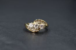 A 14ct gold cubic zirconia trilogy ring by QVC having gem set crossover shoulders and 14ct gold