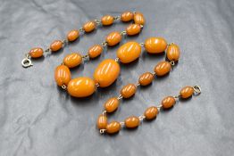 A butterscotch amber style bead necklace hacing graduated oval beads with yellow wire connector