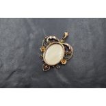 An Edwardian 9ct gold red spinel and seed pearl set locket pendant, the central oval locket in a