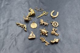 Thirteen 9ct gold loose charms of various themes including yacht, lion, stilettos, etc, approx 18.
