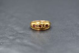 An 18ct gold diamond and red spinel set gypsy style ring, the three red spinels interspersed with
