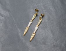 A pair of white and yellow metal articulated drop earrings with post fittings and butterflies