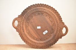 A wooden serving tray hand carved with geometrical floral patterns, w36cm