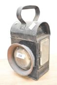 An early 20th century railway lamp having circular glass eye and shaped handle, h29cm