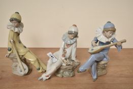 A group of three Nao by Lladro porcelain clown musician figurines in white, yellow and blue