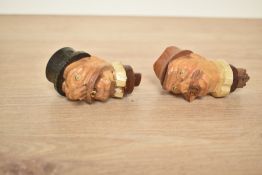 A pair of wooden bottle stoppers in the black forest style, makers label for 'Ges. Geschutzt' to