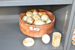 A wooden fruit bowl containing 21 onyx eggs and two candle sticks