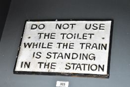 A cast iron sign reading 'DO NOT USE THE TOILET WHILE THE TRAIN IS STANDING IN THE STATION', w29cm