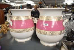 A pair of Victorian ceramic slop pails of baluster form, having shaped handles and raised on a circ