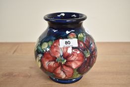 A Moorcroft pottery vase of baluster form, decorated with floral designs on a colbert blue ground,