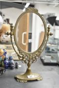 A 20th century brass dressing table mirror having oval glass and decorated with acanthus leaf