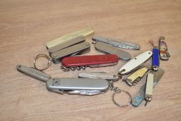 A Coronation bottle shaped pocket knife, h4.5cm, sold together with various other pocket knifes