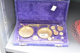 A small metal weighing scale with GM/OZ weights, sold together with box