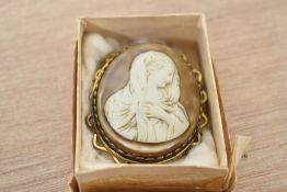 A yellow metal cameo brooch, the oval cameo depicting the Virgin Mary, in a decorative pierced