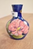 A Moorcroft vase of baluster form, decorated with pink flower on a blue ground, impressed mark to