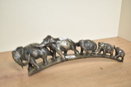A metal sculpture depicting a parade of elephants, L43cm