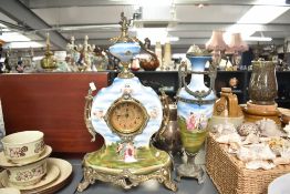 A Franz Hermle (Germany) porcelain mantel clock and garniture, hand coloured with playful cherbs
