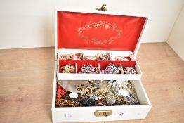 A cream faux leather jewellery box, containing an assortment of costume jewellery including faux