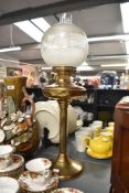 A 20th century brass and glass pedestal oil lamp, of traditional design with globular shade 68cm