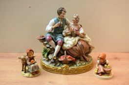 A large Capodimonte style porcelain figure group depicting a young couple seated on a wall with